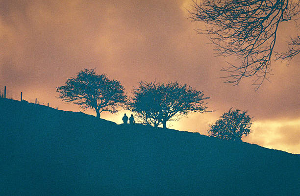 A pair of walkers in silouette, walking on Dartmoor, Lomography redscale 35mm film
