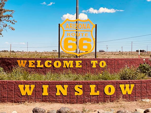 A bold roadside welcome sign stands under a clear blue sky, capturing the spirit of arrival, discovery, and the excitement of reaching a destination along a classic American road trip.