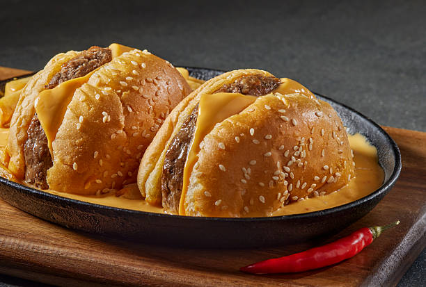 Cheeseburger Cut in Half with Spicy Cheese Sauce in Skillet