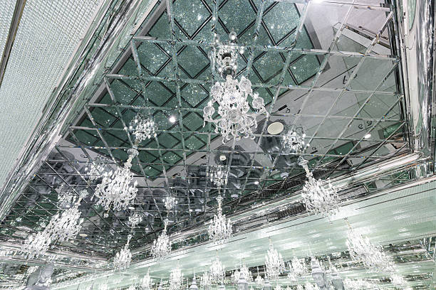 Luxury interior with mirrored ceiling and crystal chandeliers creating reflective architectural space with elegant and high-end atmosphere.