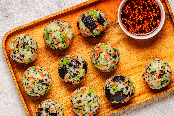 Korean rice balls (jumeokbap) with vegetables served with sauce
