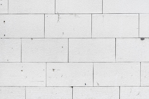 Architectural detail of white expanded polystyrene styrofoam insulation panels glued to an exterior wall in a grid pattern