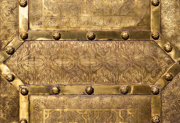 Detailed close-up of a gold-engraved decorative Moroccan metal door showcasing exceptional craftsmanship and traditional artistry.