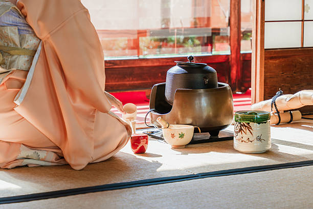 Japanese tea ceremony with matcha tea and teapot on tatami floor, preparing and serving traditional drink indoors, cultural ritual, zen lifestyle.