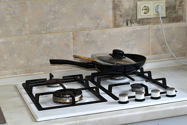A kitchen interior in a house. A frying pan sits on the gas stove.