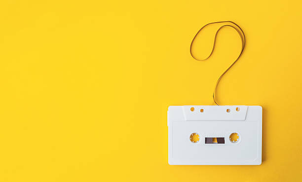 Vintage White Cassette Tape on Bright Yellow Background