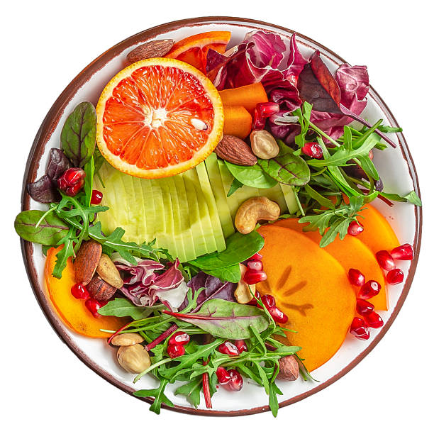Healthy vegetarian salad vegan, detox bowl with avocado, persimmon, blood orange, nuts, spinach, arugula and pomegranate, balanced food