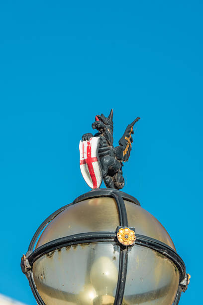 Dragon statue with a shield on a london lamppost under a clear blue sky
