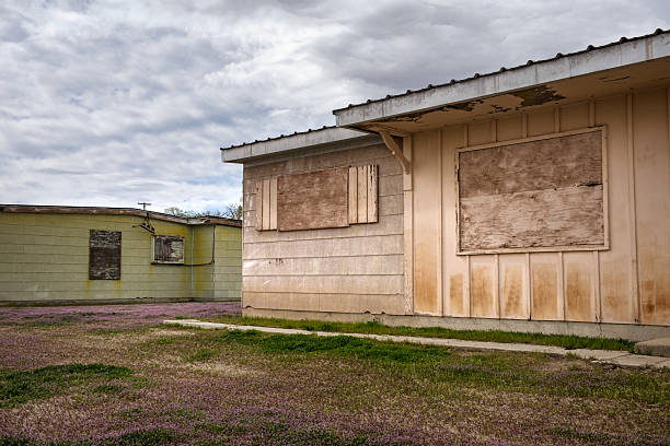 Abandened, boarded-up, single-story houses with faded paint in an old Nevada mining town.