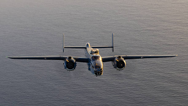 WWII era bomber (B-25 Mitchell)  flying in beautiful sunset light over the Pacific ocean