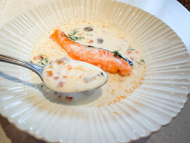 Clam chowder with clams and vegetables, topped with salmon fillets.