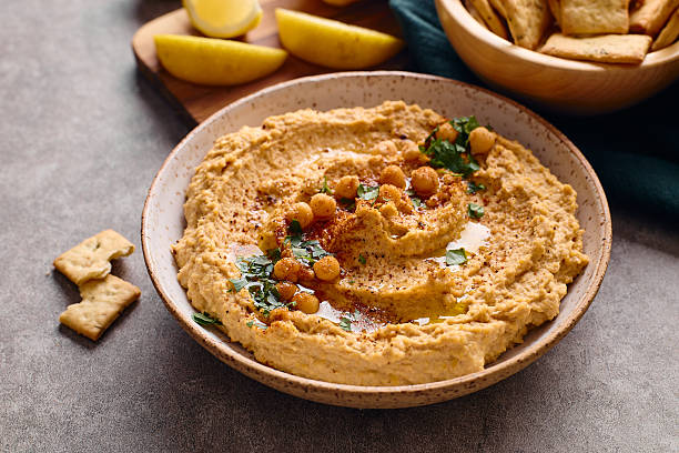 Delicious hummus with olive oil, chickpeas and parsley, close up.