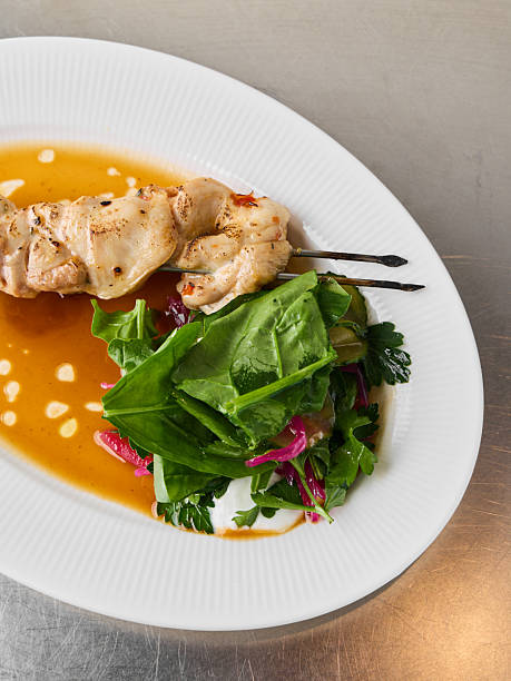 Closeup of grilled chicken with wilted spinach and citrus dressing