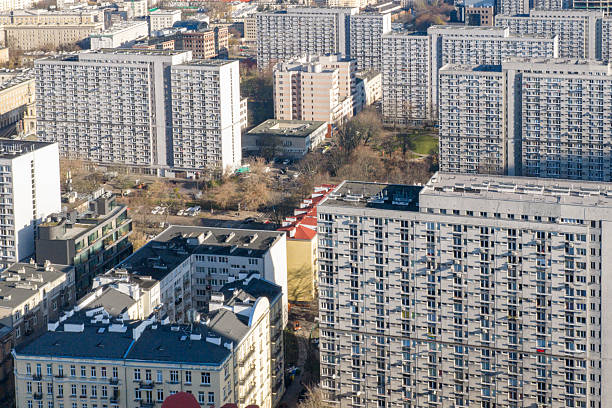 Drone view of large residential apartment blocks in Warsaw, Poland, showing dense urban housing and repetitive architectural patterns.