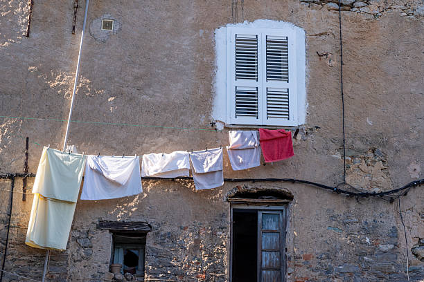 Clothesline with white and red laundry hanging to dry on a weathered building exterior