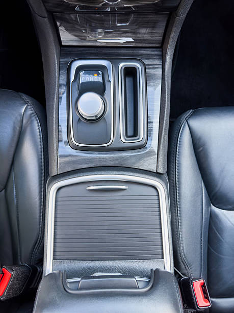 Top view of modern car center console featuring electronic gear selector, storage compartment and premium interior materials. The automotive interior detail highlights technology, comfort and contemporary vehicle design, making it ideal for car marketing, transportation concepts, automotive industry presentations and mobility related advertising with clean structured background and copy space.
