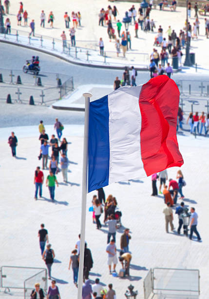 French national flag with crowd in background.