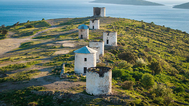 Bodrum Windmills aerial view of traditional white stone windmills located on a hill overlooking the Aegean Sea, showcasing historical architecture, cultural heritage and scenic coastal landscape in Bodrum Turkey.