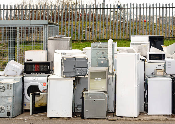Glasgow, Scotland - A collection of old household appliances, including fridges, washing machines and microwaves at a community recycling centre in Glasgow.