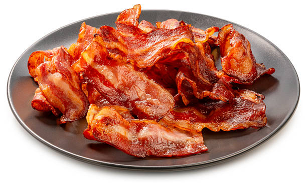 Crispy fried bacon isolated on white background, Freshly cooked and golden brown fried bacon on black dish on White Background With clipping path.
