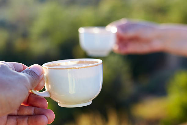Cups with a coffee in the hands of men and women. Selective focus.