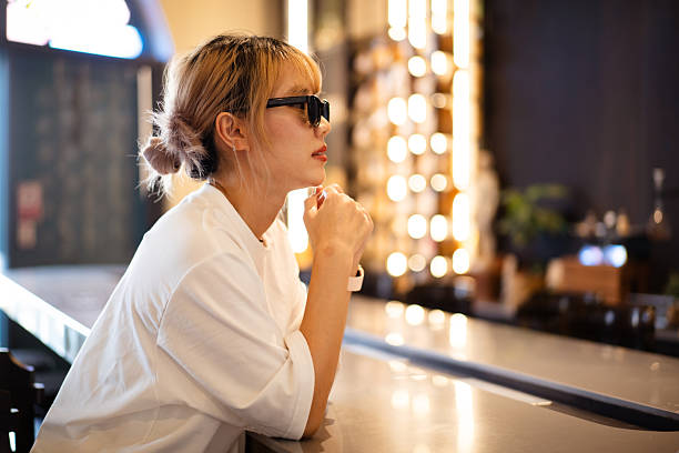 Fashionable woman posing with sunglasses in cafe setting