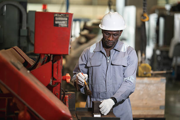 African American engineer working and control machine at auto parts factory