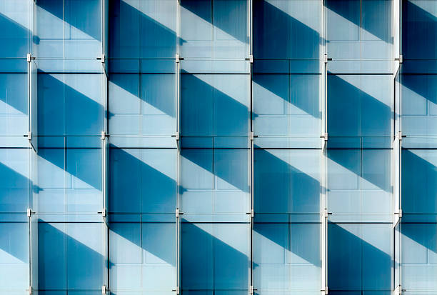 Horizontal facade with panels that project diagonal square shadows, linear composition