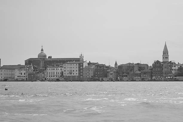 Venice cityscape showcasing historic architecture, water, and iconic bell tower under a bright summer sky in black and white