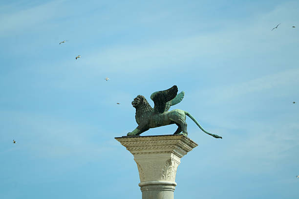 Venice's iconic winged lion sculpture on a column, a symbol of the city and its rich history under a clear sky