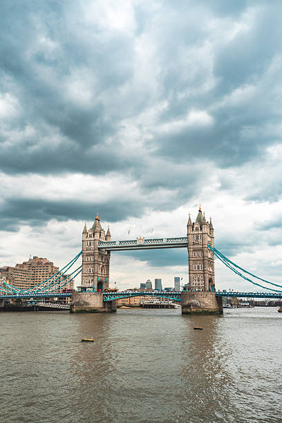 Tower bridge, a historic london landmark, stands over the river thames with a cloudy sky