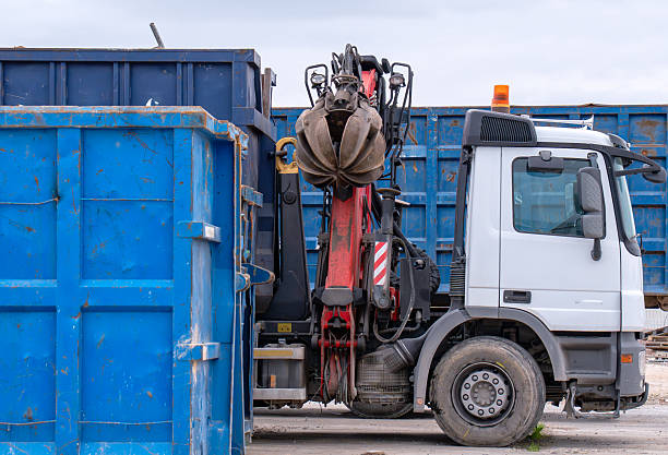 Grab truck using articulated crane arm to move scrap metal containers