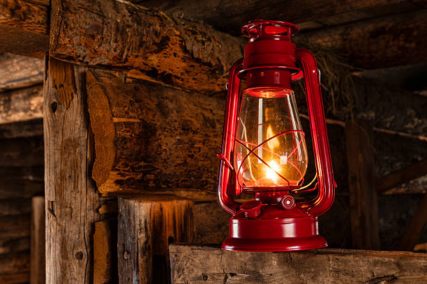 Red lantern glowing in rustic old west barn.