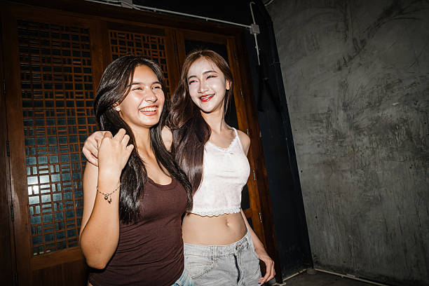 Asian young women smiling together indoors at night