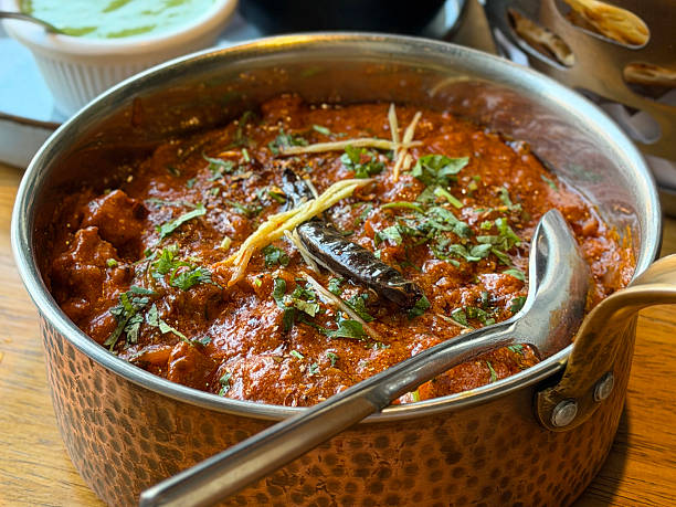 Image of savoring flavorful Indian meal: kadhai chicken, tikka masala, and butter chicken curry served hot with aromatic spices, vibrant presentation