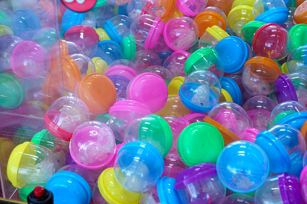 Colorful plastic capsules in claw machine vending game with prizes and toys