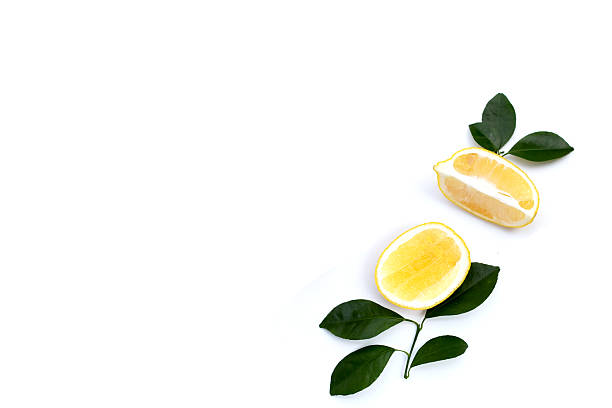 Fresh lemon with green leaves on white.