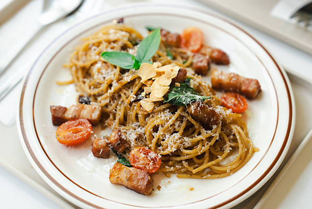 Delicious pasta dish served with crispy bacon and fresh herbs