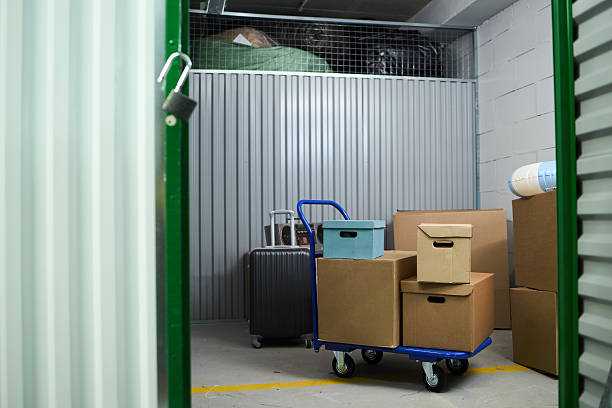 Stacked Cardboard Boxes on Trolley Standing Inside Self Storage Unit stock photo