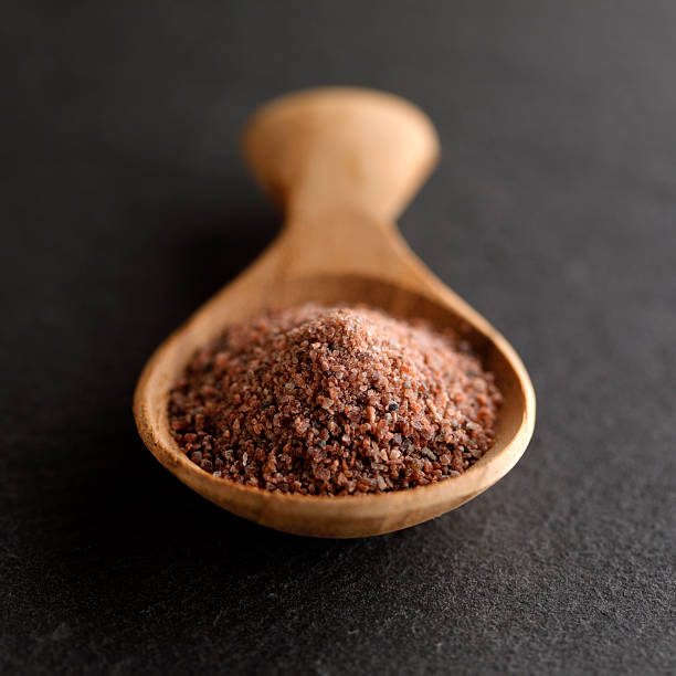 Kala namak black salt in wooden spoon