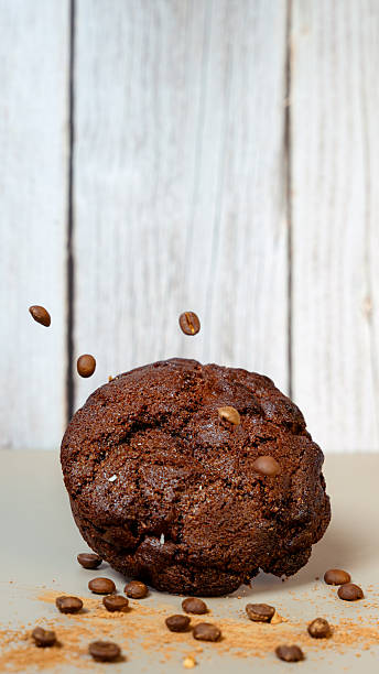 Chocolate muffin with coffee beans falling and sprinkled