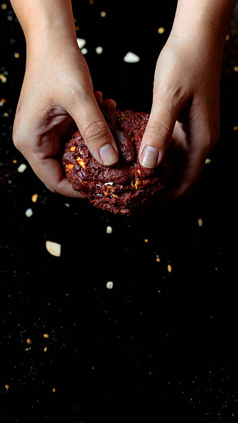 Hands holding fresh baked red velvet cookie