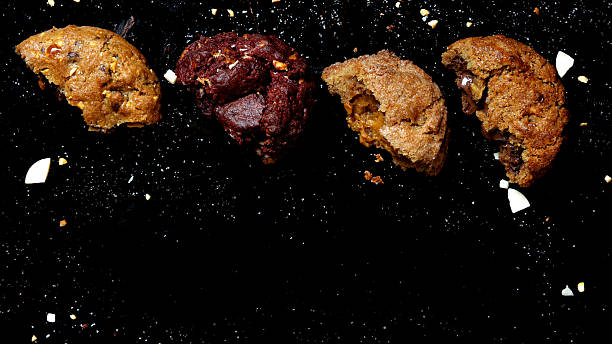 Assorted baked cookies with bites on black background