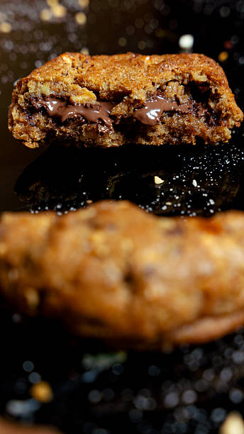 Warm chocolate chip cookie broken in half with melting chocolate filling
