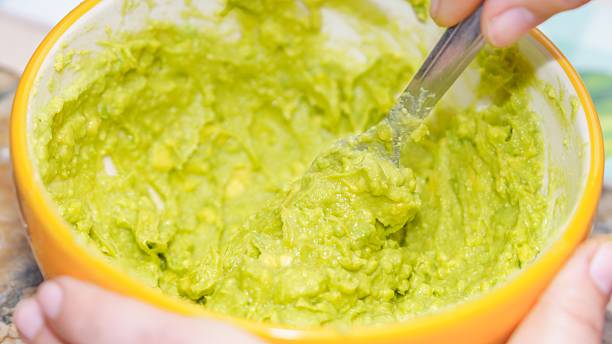 Mashed avocado preparing healthy homemade guacamole