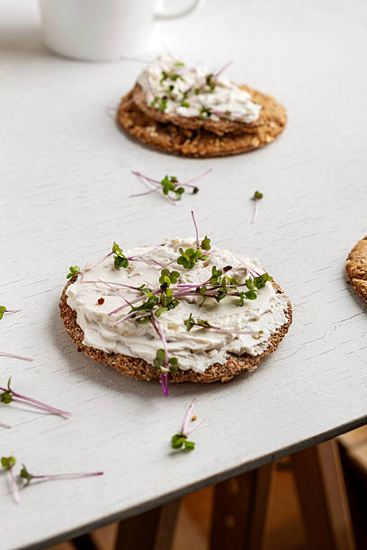 Gourmet Crispbread Topped with Savory Olive-Infused Cream Cheese and Fresh Microgreens.