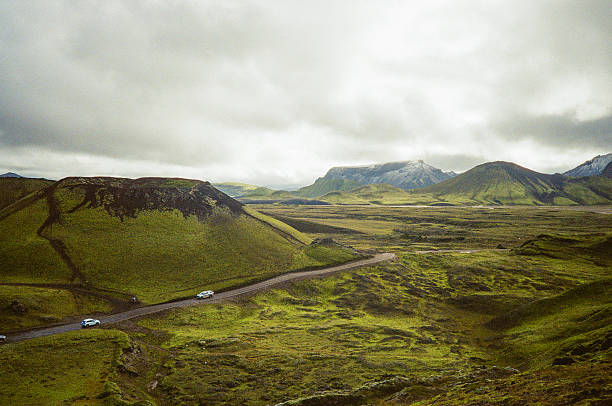 Aerial view of dramatic green volcanic landscape and 2 cars on the highland road in Landmannalaugar National park in the highlands of Iceland. Shot by point and shoot 35mm camera