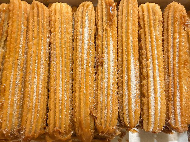 Golden Crispy Churros with alfajores in a Row