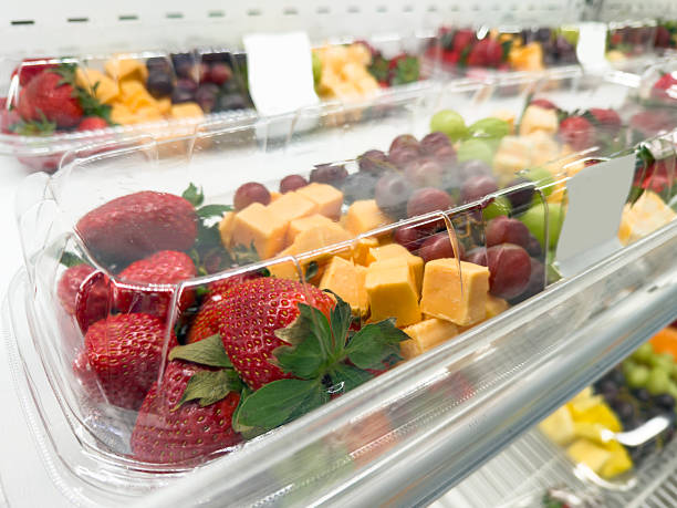 Fresh Fruit and Cheese Snack Trays in Plastic Containers on a Supermarket Shelf