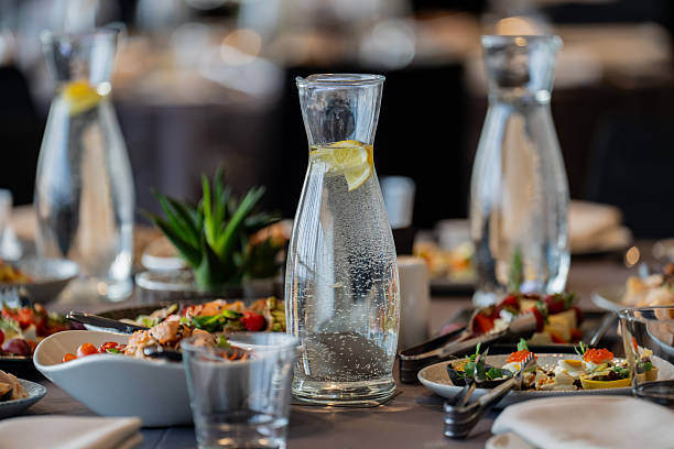 Assorted chilled beverages and healthy appetizers arranged on a dining table for a corporate function or wedding reception, highlighting modern food styling and event planning Assorted chilled beverages and healthy appetizers arranged on a dining table for a corporate function or wedding reception, highlighting modern food styling and event planning gala dinner table stock pictures, royalty-free photos & images